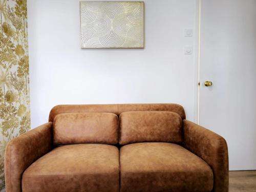 a brown couch in a room with a picture on the wall at Le Rivage in Guichen
