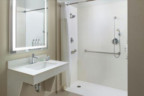 ナッシュビルにあるSpringHill Suites by Marriott Nashville Vanderbilt/West Endの洗面台とシャワー付きの白いバスルーム