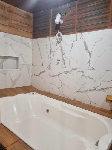 un bagno con vasca bianca e pareti in marmo di Quarto casal banheira a Conde