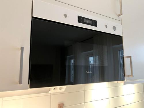 a microwave oven hanging above a kitchen counter at BRAND NEW & Nice Apartment Gothenburg in Gothenburg