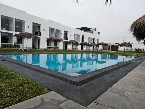 a swimming pool in front of a building at Hotel Kendari - Chincha in Chincha