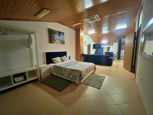 a bedroom with a bed and a living room at Sulemange Rooms Azeitão 25 minutes to Lisbon in Azeitao