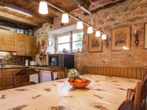 une cuisine avec une table avec un bol de fruits dessus dans l'établissement Ollie, à Saint-Cybranet