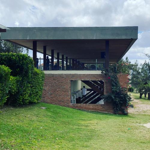 a brick building with a person standing in a window at Flat em Gravatá - Fazenda Monte Castelo - quarto superior com Wi-Fi e netflix in Gravatá