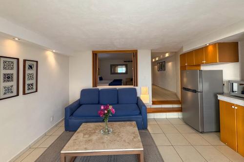 a living room with a blue couch and a kitchen at Ocean view & direct beach access! in Puerto Vallarta