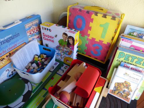 a pile of toys and books on a table at Garni Villa Siesta Park in Losone