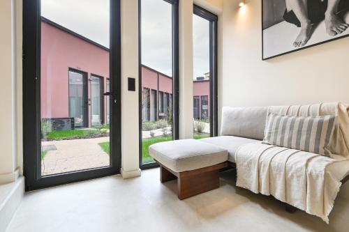 a living room with a couch and large windows at ON Apartments - Cozy - Free Parking & Pet Friendly in Porto