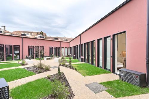 a row of pink buildings with grass at ON Apartments - Cozy - Free Parking & Pet Friendly in Porto