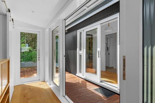 a room with sliding doors on the side of a house at Luxury Waterfront Retreat at Mahau Sound in Ohingaroa