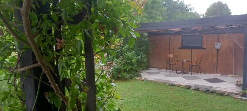 a patio with chairs and a table in a yard at Kowhai Cottage Whanganui in Whanganui