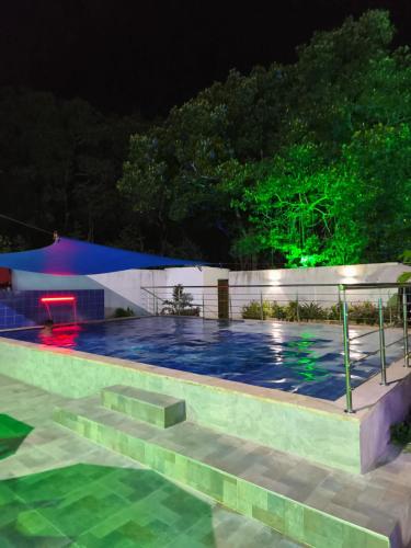 a swimming pool at night with lights at Hotel Palmetto Beach Coveñas in Coveñas