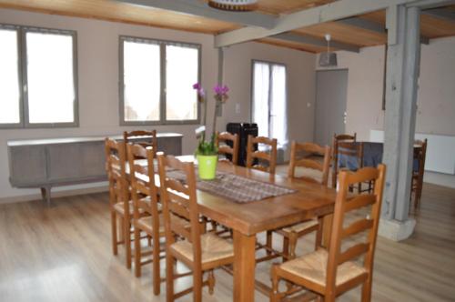 une salle à manger avec une table et des chaises en bois dans l'établissement Au Passage des Grues, à Drosnay