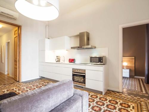 a living room with a couch and a kitchen at Rent Top Apartments Rambla Catalunya in Barcelona