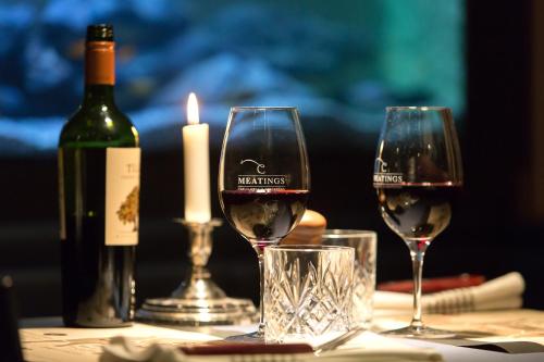 zwei Gläser Wein auf dem Tisch mit einer Flasche Wein in der Unterkunft Quality Hotel Carlia in Uddevalla
