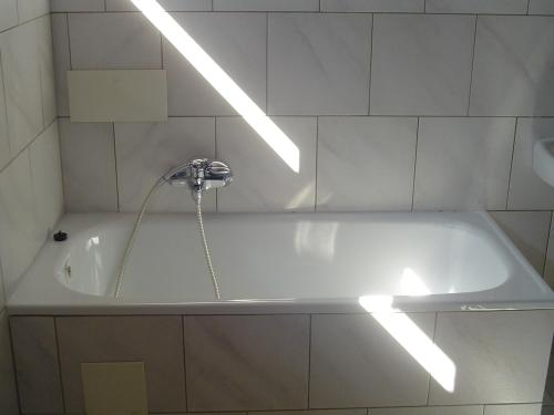 a bath tub with a faucet in a bathroom at Pension Baron in Vrchlabí