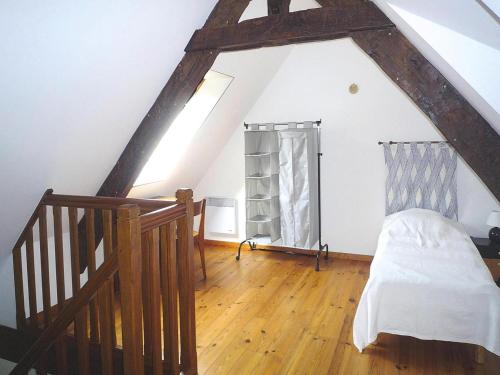 a attic room with a bed and a staircase at Stone House in Plurien near Sandy Beaches in Plurien