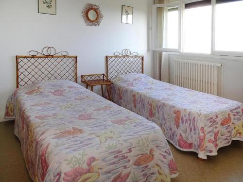 two beds sitting next to each other in a bedroom at Holiday Home in Trébeurden with Sea View in Trébeurden