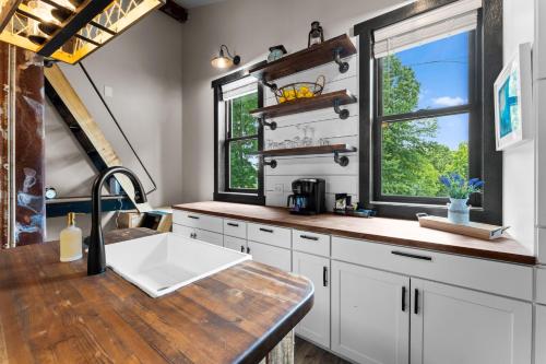 a kitchen with white cabinets and a sink and two windows at Nancy Key in Terrell