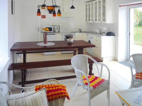 - une cuisine avec une table en bois et des chaises blanches dans l'établissement Country House near Binic Beaches, à Treguidel