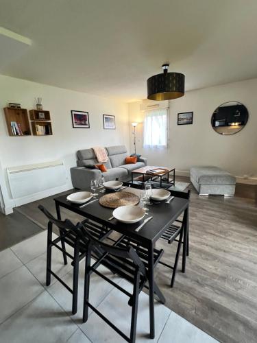 un salon avec une table et un canapé dans l'établissement Appartement 6 personnes Talence centre ville, à Talence