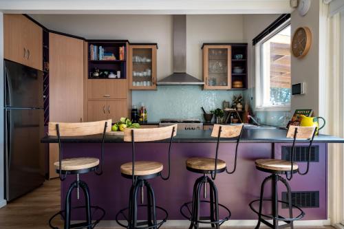 a kitchen with a purple island with bar stools at Balcombe Retreat Mornington in Mornington