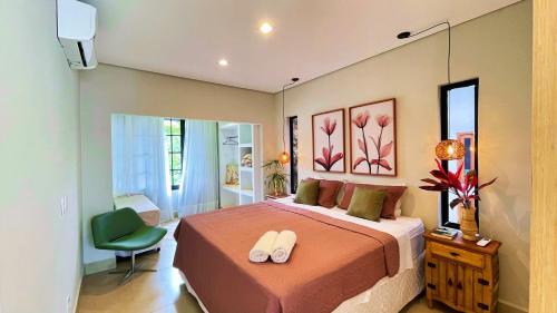 a bedroom with a bed and a green chair at Casa Paraíso in Pirenópolis