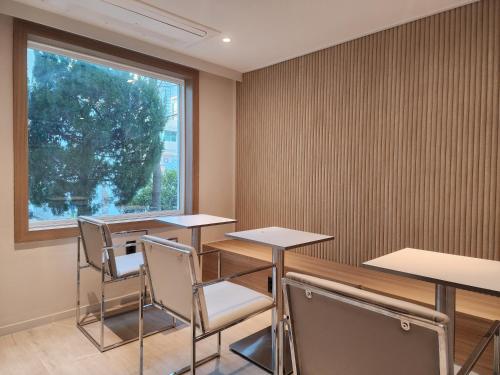 a room with two tables and chairs and a window at Hotel No 25 Gimhae cityhall in Gimhae