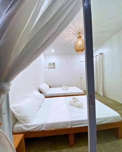 two beds in a bedroom with a canopy at Mandala Beach Cebu by Hiverooms in Medellin