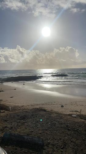 a beach with the sun rising over the ocean at Villa Ranch Bladna in Tamraght Oufella