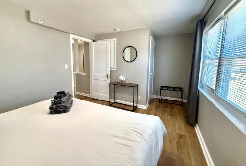a bedroom with a white bed and a window at Davenport Dwellings-Midtown 3Bed in Omaha