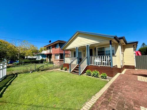 a small house with a lawn in front of it at Open Plan Coastal Beauty in Patonga Beach in Patonga