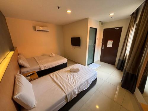 a hotel room with two beds and a television at Signature Hotel by Easy Nap in Puchong