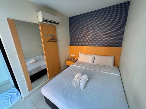 a small bedroom with a bed and a mirror at Signature Hotel by Easy Nap in Puchong