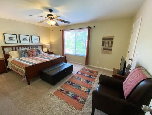 ein Schlafzimmer mit einem Bett und einem Stuhl und einem Fenster in der Unterkunft Pool & Hot Tub Close to hiking trails in Kanab in Kanab