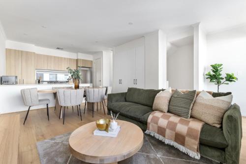 a living room with a green couch and a table at Stafford St Apartments by Urban Rest in Adelaide
