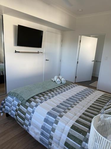 a bedroom with a large bed with a tv on the wall at Shoreline Bliss in South Beach