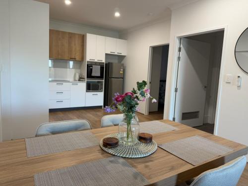 a dining room table with a vase of flowers on it at Shoreline Bliss in South Beach