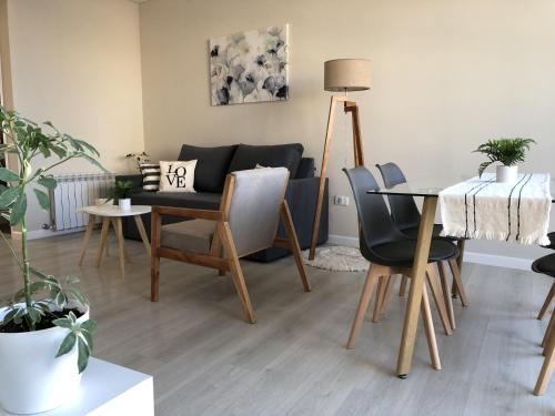 a living room with a table and chairs and a couch at Departamento JACARANDA con cochera in Bahía Blanca