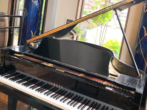 a black piano sitting in front of a window at Birdland - Vacation STAY 81132v in Seki
