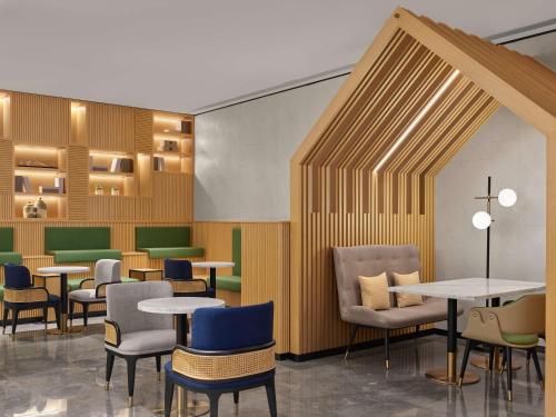 a waiting area with tables and chairs and tablesktop at Hilton Garden Inn Huangshan Scenic Area South Gate in Huangshan