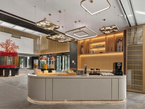 a large lobby with a counter in a building at Hilton Garden Inn Huangshan Scenic Area South Gate in Huangshan