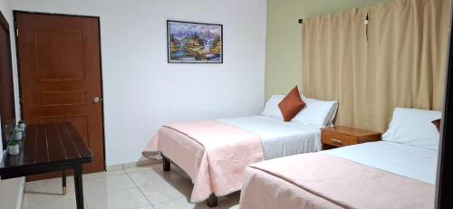 ein Hotelzimmer mit zwei Betten und einem Tisch in der Unterkunft El Ausente in Ciudad Valles