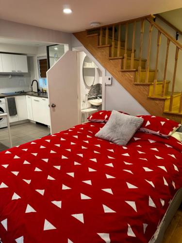 a red bed in a room with a staircase at Riad Sang Neuf in Quebec City