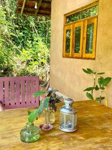 a wooden table with two vases on top of it at Hello Homestay in Galle