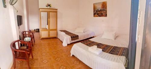 a room with three beds in a room at Hong Minh Guesthouse in Mù Cang Chải