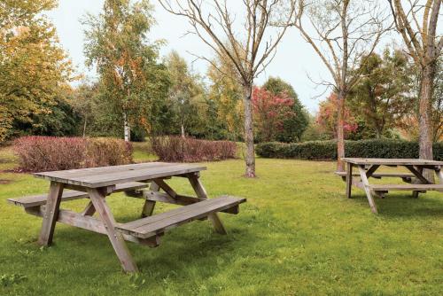 a wooden picnic table in a grassy area at Days Inn by Wyndham Donington in Castle Donington