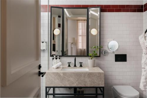 a bathroom with a sink and a mirror at Kimpton Margot Sydney by IHG in Sydney