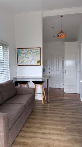 a living room with a couch and a table at LOW HEAD beachside bungalow "Cockle Shell" in Low Head