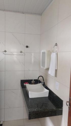 a bathroom with a sink on a black counter at Restaurante e Petiscaria Tucunaré Azul in Coruripe