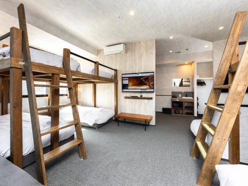 a bedroom with two bunk beds and a tv at WELLSTAY Namba in Osaka